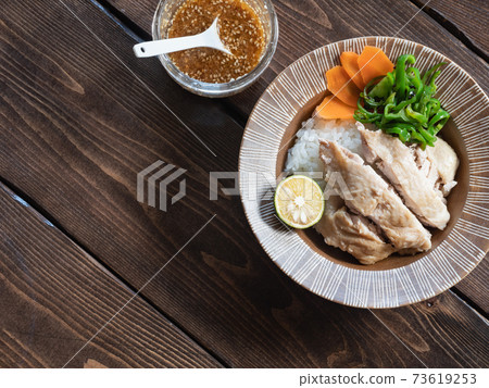 Chicken dish on top of rice, Hainan chicken rice and sauce. 73619253
