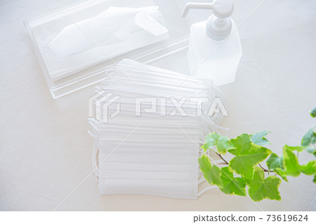 A bunch of many non-woven masks, alcohol bottles, tissue paper 73619624