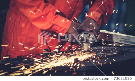 Professional mechanic is cutting steel metal. Professional mechanic is cutting steel metal. 73621050