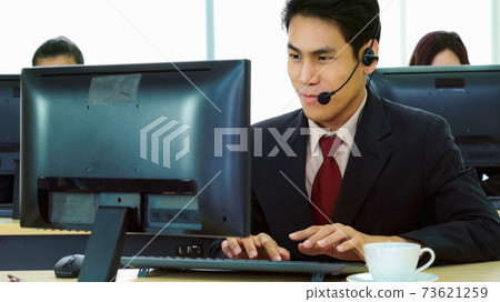 Business people wearing headset working in office Business people wearing headset working in office 73621259