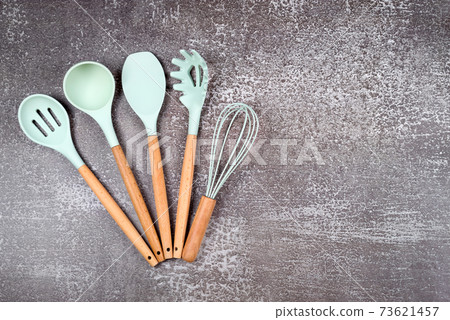 Kitchen utensils, home kitchen tools, mint rubber accessories on dark background. Restaurant, cooking, culinary, kitchen theme. Silicone spatulas and brushes, free space for text Kitchen utensils, home kitchen tools, mint rubber accessories on dark background. Restaurant, cooking, culinary, kitchen theme. Silicone spatulas and brushes, free space for text 73621457