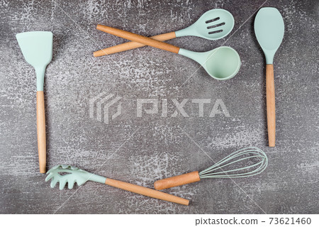 Frame made with kitchen utensils, home kitchen tools, mint rubber accessories on dark background. Restaurant, cooking, culinary, kitchen theme. Silicone spatulas and brushes, free space for text 73621460