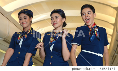Cabin crew dancing with joy in airplane 73621471