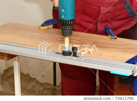 Man with milling cutter in action at the workshop. Man with milling cutter in action at the workshop. 73621706
