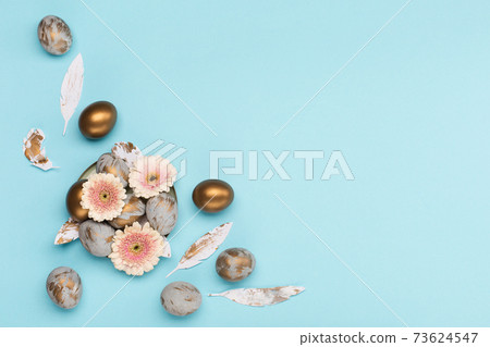 Easter Decoration with gray golden eggs, quail feathers, flowers on blue background. Happy Easter card concept, top view. 73624547