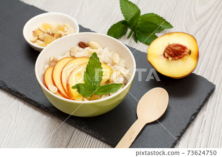 Sorghum salad with nuts and fresh peach on stone board. 73624750