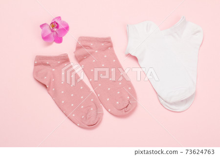 Two pairs of women socks on pink background. Two pairs of women socks on pink background. 73624763