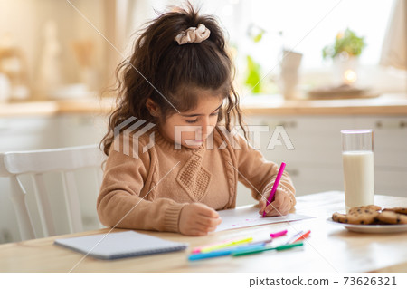 Indoor Portrait Of Small Adorable Girl Drawing Picture At Table In Kitchen Indoor Portrait Of Small Adorable Girl Drawing Picture At Table In Kitchen 73626321