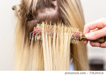 Blonde hair extensions procedure in beauty salon Blonde hair extensions procedure in beauty salon 73626418