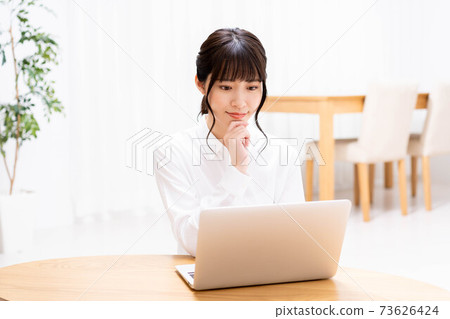 在客廳裡使用筆記本電腦的女士 在客廳裡使用筆記本電腦的女士 73626424