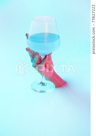 Close up female hand gesturing from the milk bath with soft glowing in neon light Close up female hand gesturing from the milk bath with soft glowing in neon light 73627222