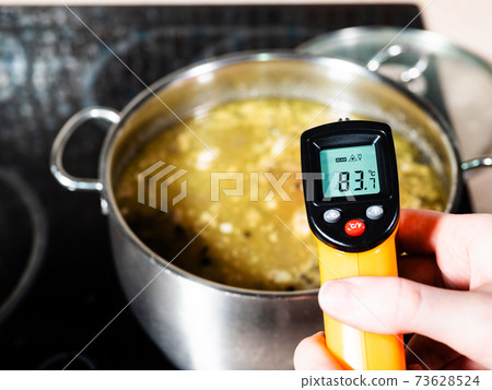 measuring temperature of hot soup by thermometer measuring temperature of hot soup by thermometer 73628524