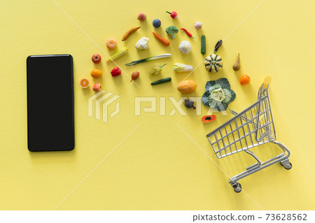 Online shopping concept - different foods and phone on yellow background Online shopping concept - different foods and phone on yellow background 73628562