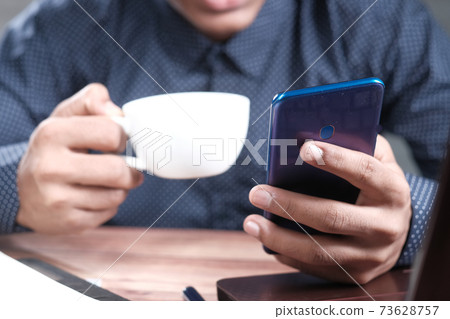 man working from home using smart phone man working from home using smart phone 73628757