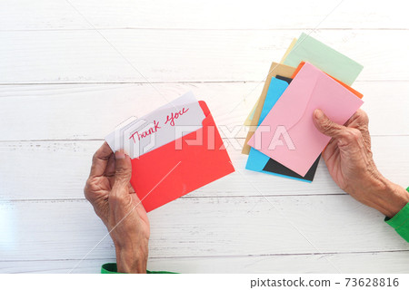 senior women's hand holding thank you letter , rear view  73628816