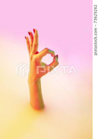 Close up female hand gesturing from the milk bath with soft glowing in neon light Close up female hand gesturing from the milk bath with soft glowing in neon light 73629262