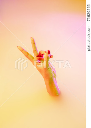 Close up female hand gesturing from the milk bath with soft glowing in neon light Close up female hand gesturing from the milk bath with soft glowing in neon light 73629263