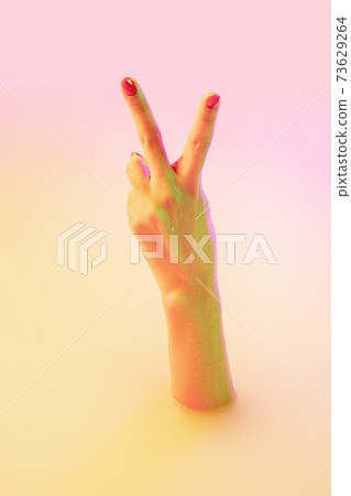 Close up female hand gesturing from the milk bath with soft glowing in neon light 73629264