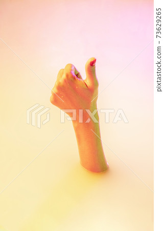 Close up female hand gesturing from the milk bath with soft glowing in neon light Close up female hand gesturing from the milk bath with soft glowing in neon light 73629265