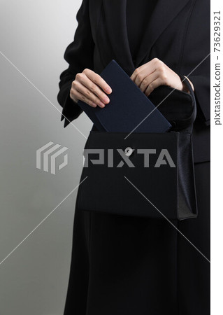 一名年輕女子試圖從袋子裡拿出劍的手[葬禮] 73629321