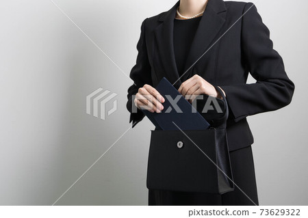 一名年輕女子試圖從袋子裡拿出劍的手[葬禮] 73629322