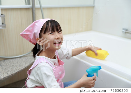 A 5-year-old girl helping to clean the bath 73630203