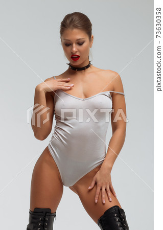 Alluring young woman in black underwear and boots 73630358