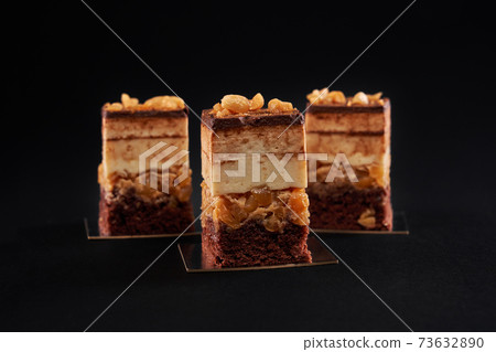 Chocolate biscuit mousse cake pieces isolated on black. Chocolate biscuit mousse cake pieces isolated on black. 73632890