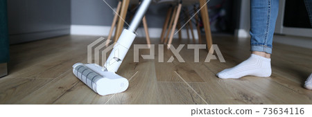 The woman in apartment washes the floor with mop The woman in apartment washes the floor with mop 73634116