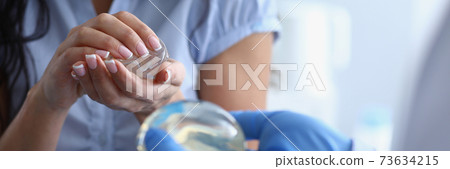 Young woman at the clinic chooses breast implants Young woman at the clinic chooses breast implants 73634215