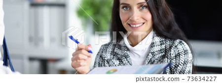 Woman boss holds a pen to fix the report 73634227