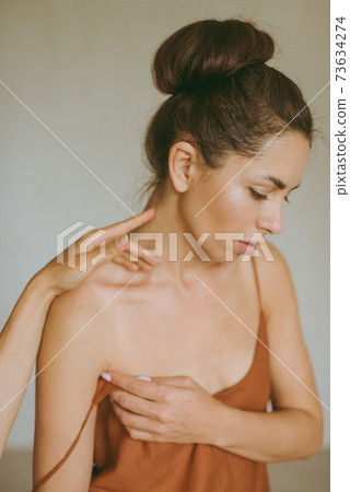 Female hands gently touch the young attractive brunette woman. Female hands gently touch the young attractive brunette woman. 73634274