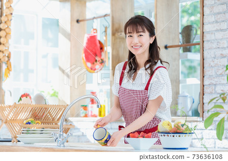 Young woman standing in the kitchen Young woman standing in the kitchen 73636108
