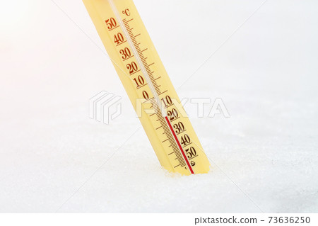 Thermometer on snow shows low temperatures - zero. Low