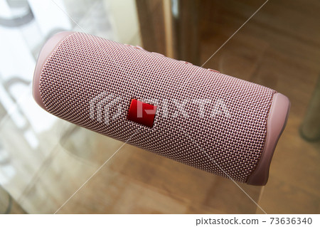 Portable pink bluetooth and wireless speaker on a glass surface. Portable pink bluetooth and wireless speaker on a glass surface. 73636340