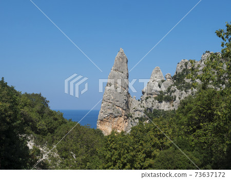 A view of limestone rock pillar Aguglia at Cala Goloritze beach at Gulf of Orosei. Famous travel destination. Sardinia, Italy, September 73637172