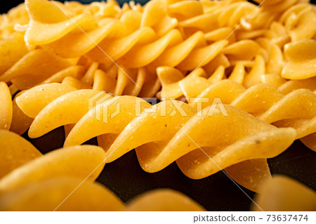 Macro photo of dry heap of fusilli pasta 73637474