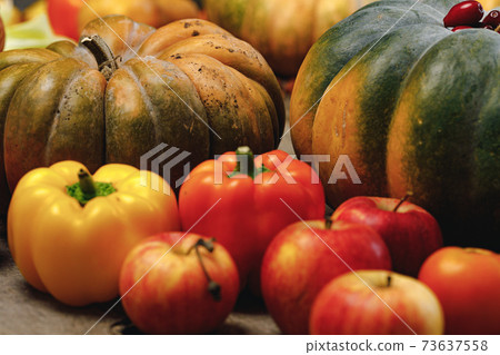 Close up of scattered vegetables of pumpkin, pepper and apples 73637558