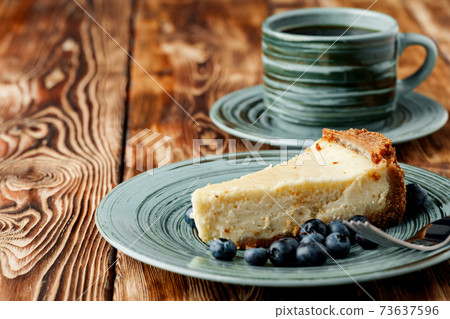 Piece of classic cheesecake on green plate 73637596