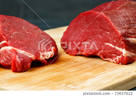 Slice of raw beef fillet on wooden board Slice of raw beef fillet on wooden board 73637622