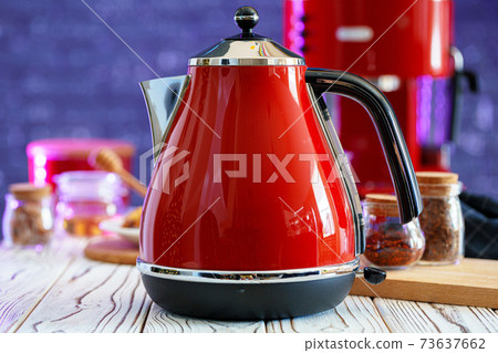 Red kettle on kitchen table close up Red kettle on kitchen table close up 73637662