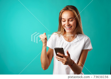 Young blonde casual girl using her smartphone. 73638156