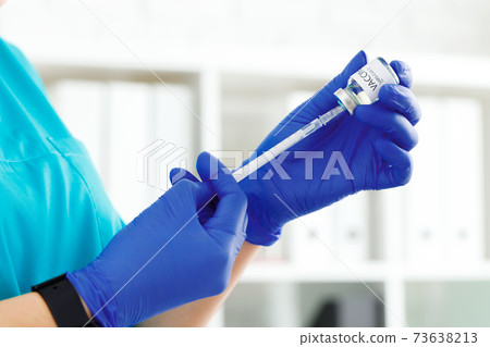 Doctor hands holding covid-19 vaccine preparing for vaccination of a patient 73638213