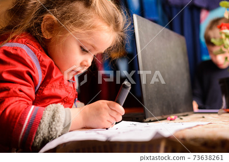 Preschool girl learns to draw a circle, black circles on a white sheet of paper, happy child. Preschool girl learns to draw a circle, black circles on a white sheet of paper, happy child. 73638261