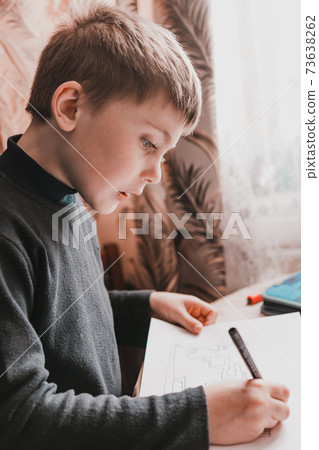 The boy at home after school draws pictures, children's drawings. The boy at home after school draws pictures, children's drawings. 73638262
