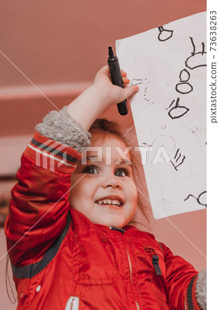 Preschool girl learns to draw a circle, black circles on a white sheet of paper, happy child. Preschool girl learns to draw a circle, black circles on a white sheet of paper, happy child. 73638263