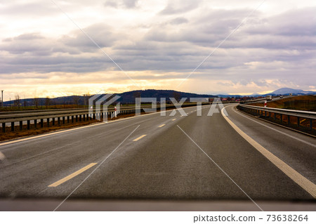 Empty track outside city with fields and road marking Empty track outside city with fields and road marking 73638264