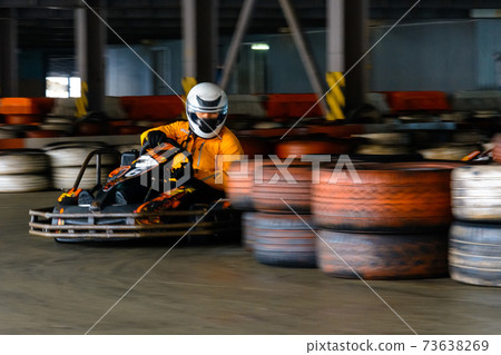Dynamic karting competition at speed with blurry motion on an equipped racecourse Dynamic karting competition at speed with blurry motion on an equipped racecourse 73638269