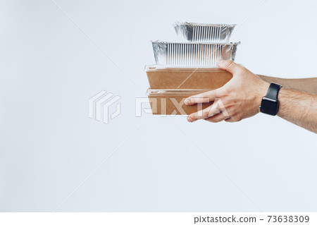Courier hands giving packed food delivery close up Courier hands giving packed food delivery close up 73638309