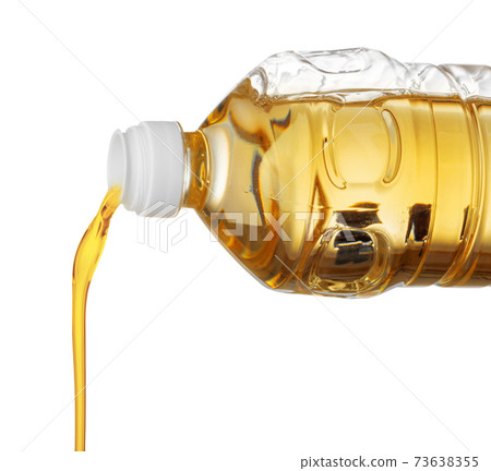 Pouring oil for cooking in a bottle isolated on white background. 73638355